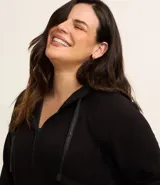 Campera deportiva negra con capucha ajustable con cordones, cierre frontal con cremallera, bolsillos tipo canguro y mangas raglán. Confeccionada en poliviscosa.