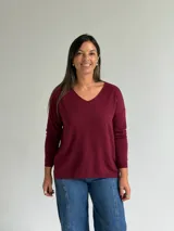 Sweater de punto en color bordó, con escote en V, mangas largas y diseño de corte recto con dobladillo ligeramente más largo en la parte posterior.