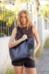 Bolso tote grande de cuero negro con textura croco, doble asa de hombro y costuras laterales en contraste color crudo.