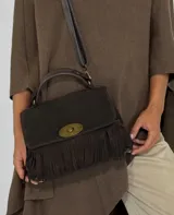 Cartera de mano negra de gamuza con flecos y cierre dorado.