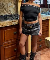 Mini falda de denim gris con lavado ácido, detalles de tachas y estampado de texto.