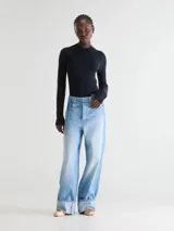 Jean tiro bajo de calce amplio y piernas anchas, confeccionado en denim de algodón rígido, con diseño de cinco bolsillos, ruedos doblados hacia arriba y cinturón desmontable.