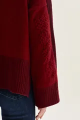 Sweater de tejido de punto en color beige, con mangas largas que presentan detalles de textura en relieve y paneles laterales en tono gris. Confeccionado en lana italiana, cuenta con puños acanalados y detalles en lurex.