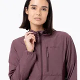 Campera cortaviento Merrell de diseño técnico, confeccionada en nylon reciclado con tratamiento repelente al agua. Presenta capucha ergonómica, cierre frontal completo, bolsillo con cierre en el pecho y mangas largas con puños elásticos.
