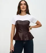 Blusa peplum sin breteles confeccionada en PU color bordó, con escote corazón y cierre posterior por cremallera. Presenta un diseño estructurado con ruedo evasé.