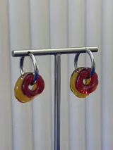 Aros tipo argolla de plata 925 con dijes circulares de vidrio en colores rojo y ámbar.