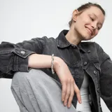 Pulsera elástica plateada con cuentas irregulares de aleación de metales bañadas en plata y pieza central con el logo de la marca Uno de 50 grabado.