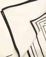 Fular cuadrado de lana con estampado geométrico de líneas negras sobre fondo color crema.