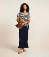 Blusa de viscolino a rayas verticales azul marino y blanco, con escote en V cruzado, mangas cortas y cinturón de cuerda en la cintura.