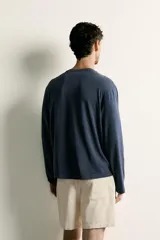 Remera manga larga de corte regular, color azul marino, con cuello redondo y un bolsillo aplicado en el pecho.