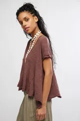 Remera marrón de mezcla de algodón y lino, con escote en V, mangas cortas caídas, calce fluido y detalles de costuras expuestas con bordes sin rematar.