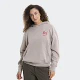 Buzo con capucha color gris topo, de corte holgado, con bolsillo frontal tipo canguro y logo de la marca bordado en color rojo en el pecho.
