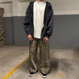Pantalón de corte super baggy con estampado de piel de serpiente en tonos grises y beige.