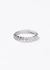 Anillo tipo media alianza elaborado en plata 925, con diseño de piedras engastadas en zirconia a lo largo de la mitad superior.