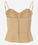 Blusa estilo corset color beige claro, con escote corazón y breteles finos. Presenta un corte ajustado en el torso y un volado peplum en el bajo.