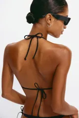 Top de bikini triangular color negro con relleno extraíble y tiras para atar en el cuello y la espalda.
