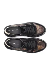 Zapatillas urbanas con estampado de víbora en tonos marrones y negros, con detalles en cuero liso negro y aplique dorado en el talón.