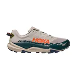 Championes de trail running Hoka Torrent 4, con capellada de malla técnica en color beige, entresuela con diseño ondulado en verde oscuro y detalles en naranja vibrante. Presenta suela con tracción optimizada para terrenos irregulares.