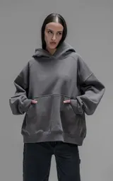 Hoodie oversize de corte crop, color gris oscuro, confeccionado en frisa de algodón. Presenta capucha forrada, bolsillo tipo canguro frontal y puños elásticos.