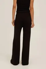 Pantalón de punto acanalado negro de tiro alto, pierna recta y relajada, con cintura elástica y cordón ajustable, y bolsillos laterales.
