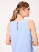 Vestido midi sin mangas de corte recto y holgado, color beige, con cuello redondo y bolsillos laterales.