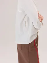 Remera de algodón con cuello redondo y manga larga. Presenta un diseño con costuras horizontales a la altura del pecho y costuras verticales en las mangas, brindando un detalle distintivo a la prenda.