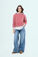 Sweater tejido de silueta relajada, textura suave y acabado moteado en color rojo y blanco, con cuello redondo y mangas largas.