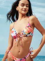 Top de bikini tipo triángulo con copas removibles, tirantes finos para anudar al hombro y diseño ajustable en el centro con lazos.