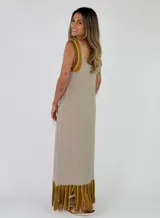 Vestido largo negro de punto con tirantes anchos rayados en tonos marrones y amarillos, escote redondo y flecos multicolor en el ruedo.