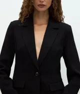 Blazer de sastrería marca Cortelle con diseño entallado tipo reloj de arena, solapas clásicas, cierre frontal de un botón, bolsillos con solapa y mangas largas.