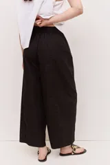 Pantalón negro de tiro alto con cintura elastizada y cordón ajustable, de corte amplio y relajado, con bolsillos laterales.