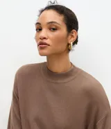 Blusa de manga corta amplia y sisas desplazadas, confeccionada en punto leve de viscosa y poliamida, con cuello redondo ligeramente alto.