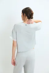 Pijama de dos piezas en color gris melange, compuesto por una remera de manga corta con detalles de encaje en los bordes y un pantalón de corte recto con cintura elástica y detalle de encaje en la pretina.