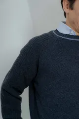 Sweater marrón de lana lambswool con cuello redondo y mangas largas. Presenta un diseño de punto texturizado en el cuerpo y mangas con detalle de punto acanalado en hombros y puños.
