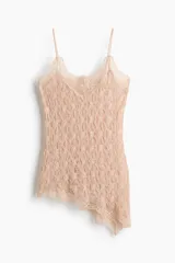 Top color beige de punto liviano con efecto encaje, escote en V, breteles finos y bajo asimétrico con ribetes festoneados.