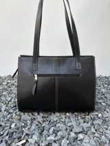 Cartera tipo shopper de cuero genuino marrón con panel central de textura símil cocodrilo y herrajes metálicos plateados.