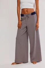Pantalón de descanso de tiro alto y pierna ancha con micro-rayas horizontales. Cuenta con cintura elastizada acanalada en tono azul marino y cordón ajustable.