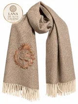 Pashmina de lana merino color beige, con bordado del Escudo Nacional en tono marrón en uno de sus extremos y terminación de flecos en los bordes inferiores.