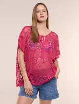 Poncho de tejido calado color beige, con mangas cortas, aberturas laterales y lazos ajustables en el cuello. Modelo Do Everything In Love.