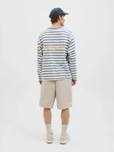 Short color beige de tiro medio con cierre de cremallera, bolsillos delanteros y traseros.