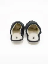 Pantuflas abiertas color gris con textura acanalada y forro interno de corderito sintético blanco.