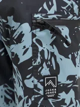 Pantalón técnico de ski impermeable y cortaviento, con diseño estampado de montañas en tonos azul y negro. Cuenta con cierre frontal, bolsillos laterales con cremallera, refuerzos en la parte inferior y polainas internas para protección contra la nieve.