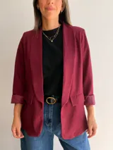 Blazer sastrero de corte clásico con solapas frontales y bolsillos con solapa. Presenta mangas largas con puños vueltos y un diseño forrado que ofrece una caída estructurada y elegante.