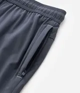 Bermuda de running para hombre, color beige claro, confeccionada en microfibra tecnológica. Presenta cintura elástica con cordón ajustable y bolsillos funcionales.