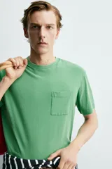 Camiseta de corte regular con cuello redondo, manga corta y bolsillo plastrón en el pecho. Presenta un acabado de color verde con efecto lavado.