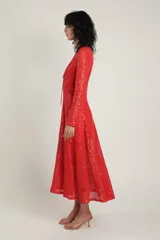 Vestido largo de crochet rojo con lentejuelas, escote en V profundo con detalle de cuerdas en el pecho y manga larga.