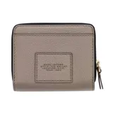 Billetera Marc Jacobs The Mini Compact Wallet de cuero color marrón, con diseño plegable, compartimentos para tarjetas y cierre de cremallera.