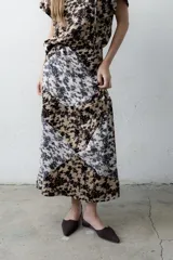 Falda larga y recta con diseño en bloques geométricos que combinan estampado floral abstracto en tonos beige, blanco y negro.