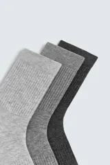Pack de tres pares de calcetines de algodón, con tejido acanalado (rib) en la caña. Los colores son gris claro, gris medio y gris oscuro/negro.