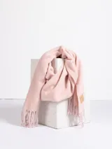 Bufanda de tejido suave en color rosado, con diseño liso y terminaciones con flecos en los extremos. Incluye una etiqueta de cuero sintético con el logo de la marca en uno de los bordes.
